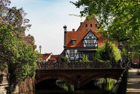 An illustrative photo of a bridge over a river with a house in the background