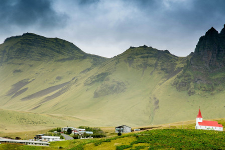 An illustrative photo of houses near hills.