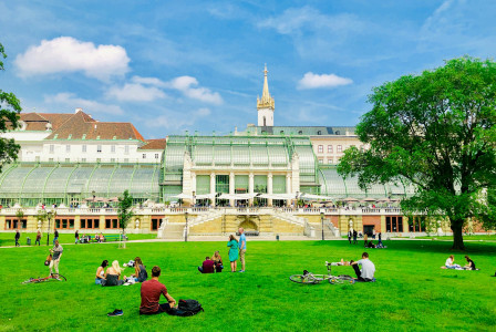 An illustrative photo of people sitting on grass in a park during daytime