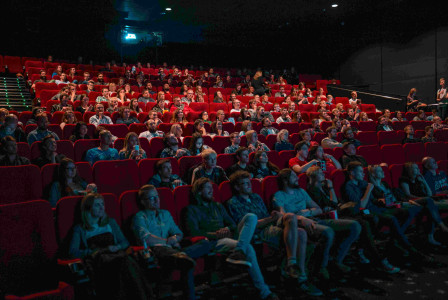 An illustrative photo of people sitting in a movie theatre.