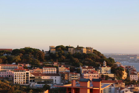 An illustrative photo of view of city buildings with a castle on a hill