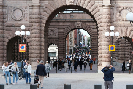 An illustrative photo of people walking through an arch in a building