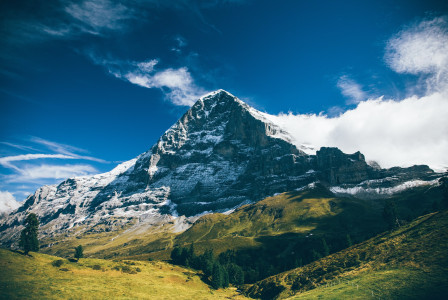 An illustrative photo of a mountain under white clouds