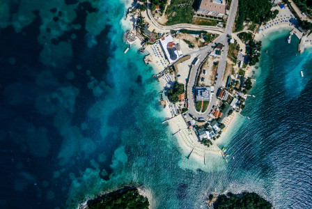 An illustrative photo of an island in a body of water with houses on the coast