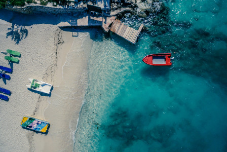 Photo by Unsplash An illustrative photo of a red boat on a body of water near a beach