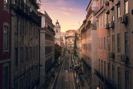 An illustrative photo of a street between buildings during sunset.