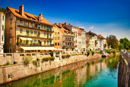 An illustrative photo of white and brown concrete buildings beside river