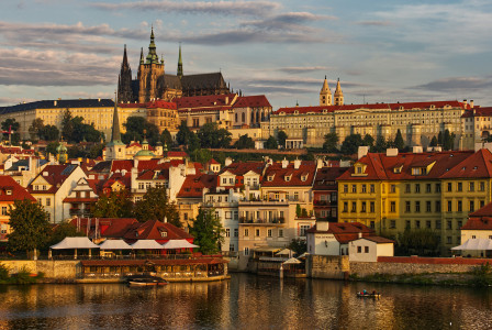 An illustrative photo of a city across the river during sunset.