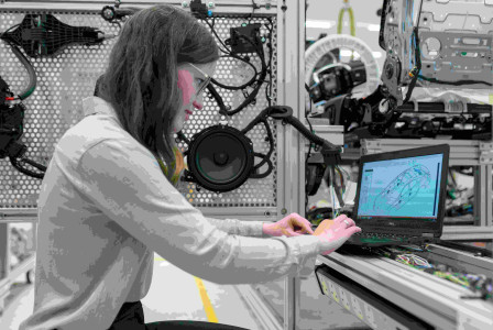 An illustrative photo of an engineer running vehicle tests on a laptop.