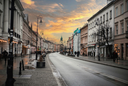 An illustrative photo of a city street with people walking on the sidewalks.