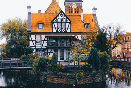 Image by Unsplash An illustrative photo of a white and orange house in the middle of a body of water.