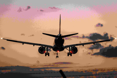 An illustrative photo of a plane landing during sunset.