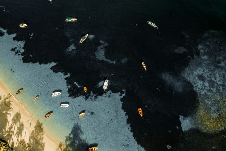 An illustrative photo of boats in a body of water near a beach.