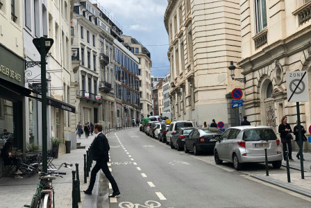 An illustrative photo of gray and black vehicles parked beside road.