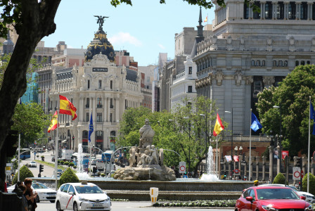An illustrative photo of cars on a road near a fountain.