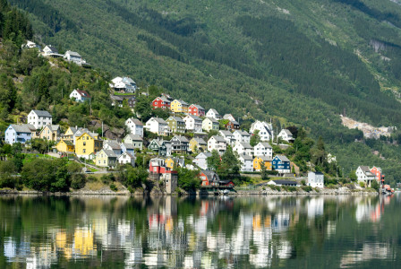 Image by Unsplash An illustrative photo of a small town on a hill with a lake in front of it.