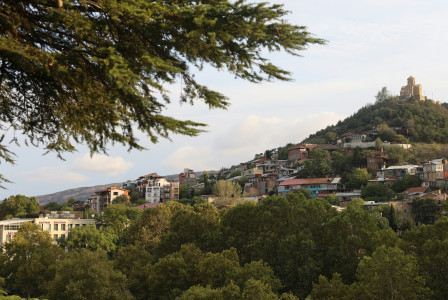 An illustrative photo of a city with a hill in the background.