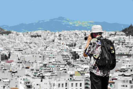 An illustrative photo of a man standing on top of a hill taking a picture.
