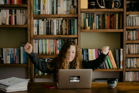 An illustrative photo of a woman sitting at a table.