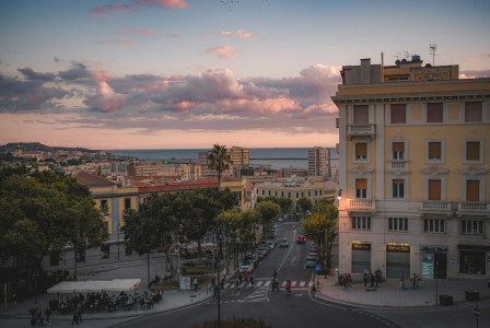 An illustrative photo of cars on a road near a building during sunset.