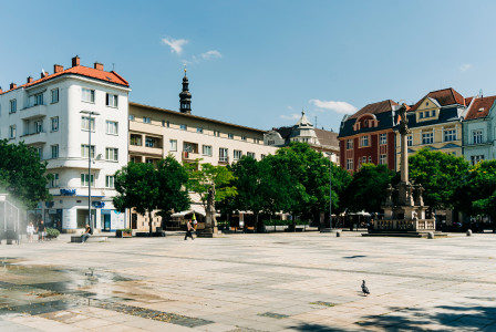 An illustrative photo of a city square with a fountain in the middle of it.