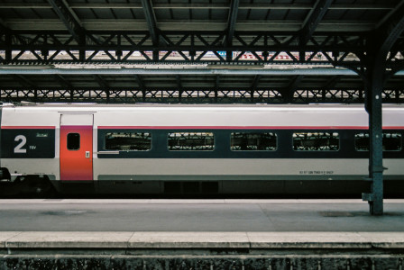 An illustrative photo of a white and red train on a train station.