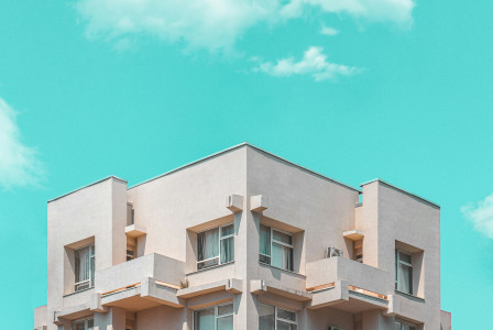 An illustrative photo of a beige concrete building under blue sky.