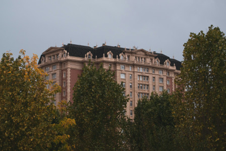 An illustrative photo of a large building surrounded by trees.