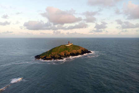 Photo by Unsplash An illustrative photo of a green and brown island under white clouds.