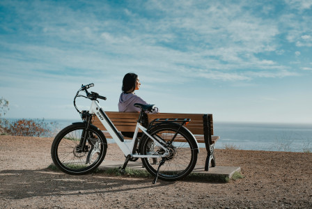 An illustrative photo of a man sitting on a brown wooden bench.