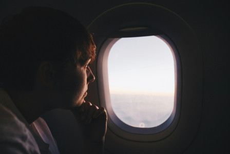 An illustrative photo of a man looking at window.