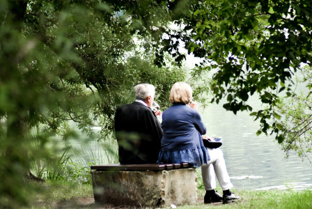 An illustrative photo of two people sitting on pavement.