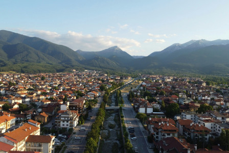 An illustrative photo of a city with mountains in the background.