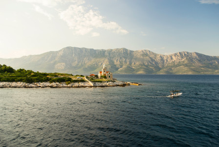 An illustrative photo of a house on an island in a body of water.