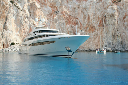 An illustrative photo of a white and blue cruise ship in blue sea.
