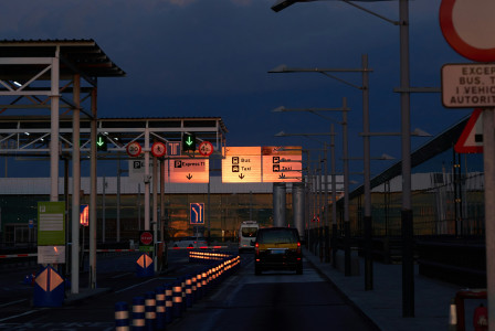 An illustrative photo of a car driving down a street at night.