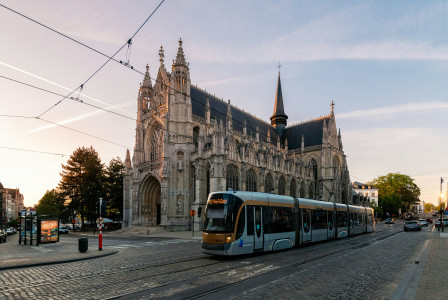 An illustrative photo of a train on a track in front of a building.