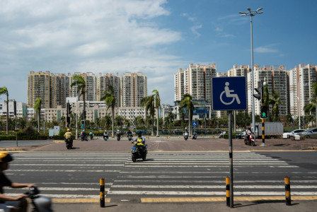 An illustrative photo of a road with skyscrapers in the background.
