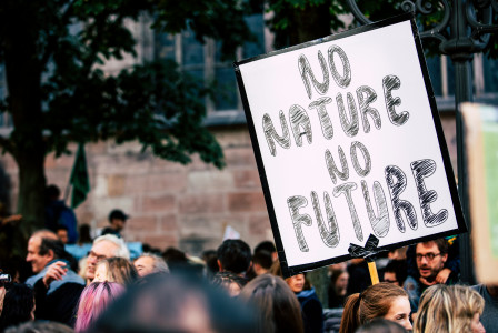 An illustrative photo of a man holding No Nature No Future sign.