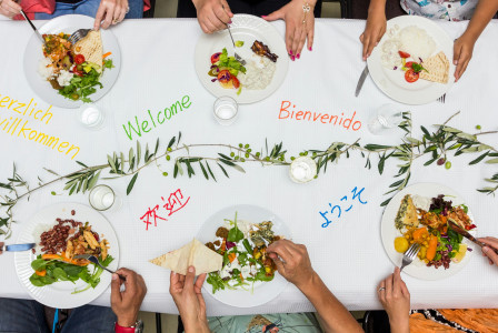 An illustrative photo of a group of people sitting around a table eating food.