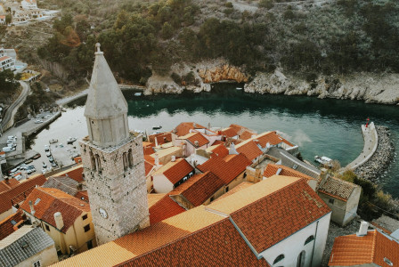 An illustrative photo of a large building with a tower by a body of water.