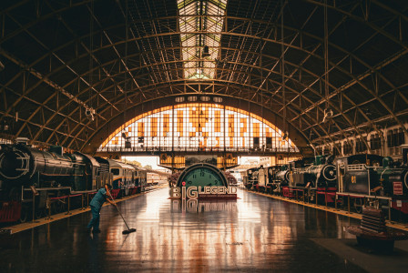 An illustrative photo of a train station with a man sweeping the floor.