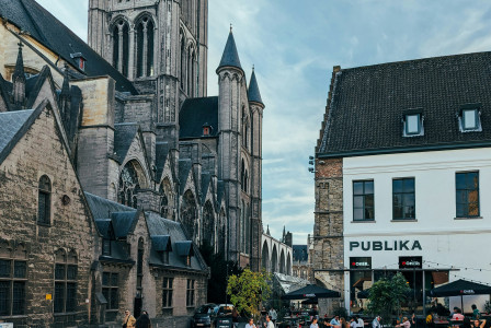 An illustrative photo of a group of people walking down a street next to tall buildings.