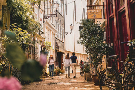 An illustrative photo of a group of people walking down a street next to tall buildings.