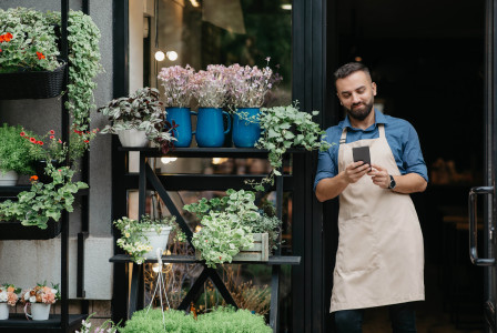 Man standing next to pot of plants