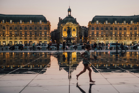 A girl running in front of a building