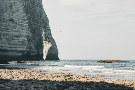Photo by Unsplash Rocky beach with a large rock formation in the background