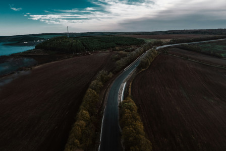 Photo by Unsplash An aerial view of a road between forest and body of water
