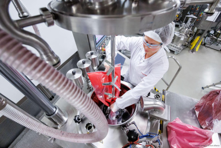 Worker in protective gear pouring materials