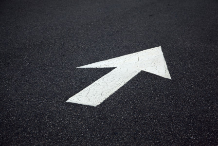 Colour photograph of white arrow on black background